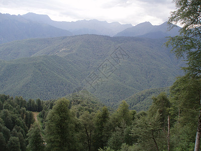 一片全景的山地景观 其山谷和森林山峰在高覆云天下山脉石头岩石房子风景旅游地平线旅行荒野远足图片