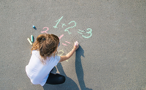 孩子在沥青上决定咕噜声 有选择的焦点学校幼儿园乐趣家庭教育数字粉笔学习童年婴儿图片