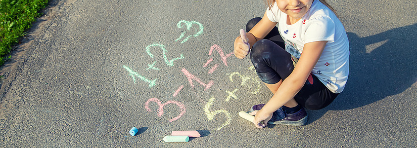 孩子在沥青上决定咕噜声 有选择的焦点数学粉笔街道乐趣操场幼儿园学校班级家庭婴儿图片