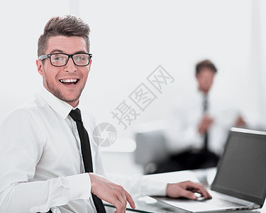 手持笔记本电脑坐在办公室的商务人士图片