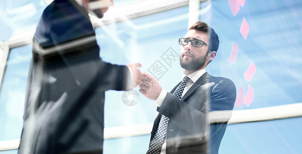 雇员在透明办公墙附近站立职场企业家战略界面男人玻璃项目成功商业办公室图片