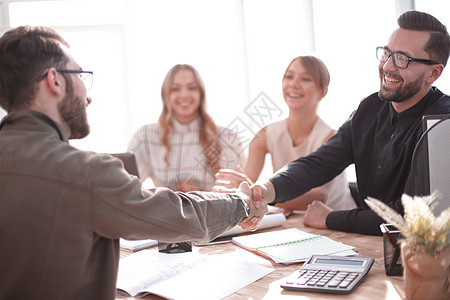 在办公室举行的一次工作会议上笑着微笑的商务人士男人电脑商务笔记本领导银行同事眼镜桌子团队图片