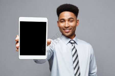 商业概念     英俊 专业的非洲商务人士向客户展示数字平板电脑 快乐屏幕手指工作室成人软垫药片微笑监视器商务工作图片