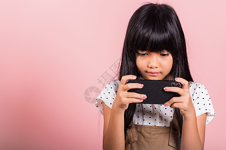 10年亚洲孩童享受使用手机社交网络媒体的游戏生活女学生童年电话微笑技术互联网女性细胞女孩女士图片