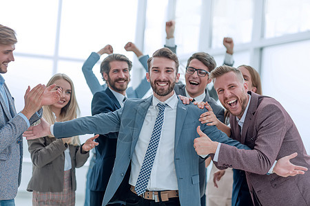 欢快的生意团队拥抱他们的领队老板微笑手势力量会议合伙商业成功胜利商务图片