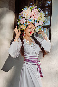 穿着白色的乌拉尼式国服和花圈的布蕾特女孩 对白小屋装扮成一朵鲜花戏服装饰品刺绣茅草民间女性丝带婚礼房子农村图片
