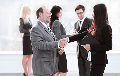 助理与一名商务人士见面 进行握手会晤 会议和伙伴关系商务服务办公室女士工作招聘合同合伙公司假期图片
