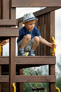 一个戴着白帽子的小男孩 站在木偶堆的顶端 看着环境图片