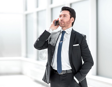 商务人士在电话上聊天工作成人人士套装窗户办公室咨询男人商业男性图片