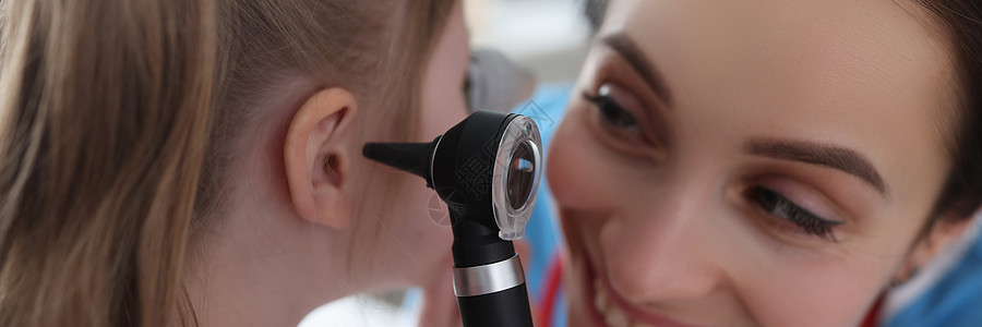 在诊所用眼透镜检查小姑娘耳朵的内妇女听力女孩耳科程序考试测试诊断儿科职业医生图片