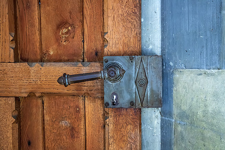 一扇旧木门的碎片 用一个伪造的钢柄木板建筑学障碍入口合页叶子金属弯曲古董防御图片