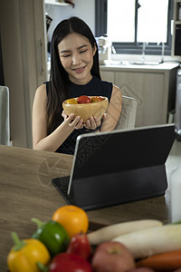 制作健康沙拉和在数字平板电脑上寻找在线食谱的素材 这些都由一位年轻女性制作图片