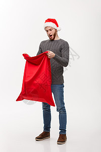 圣诞概念  英俊的长胡子帅哥 令人兴奋的开放圣塔大袋子作为礼物胡须传统火花男人服装老人解雇展示新年盒子图片