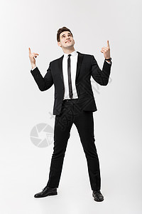 商业概念 帅哥快乐笑的年轻帅哥穿智能西装 对孤立的灰色背景指手画脚图片
