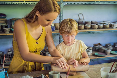 母亲和儿子在陶瓷车间做陶瓷锅作坊制造业制品创造力夫妻男人工艺女孩女性爱好图片