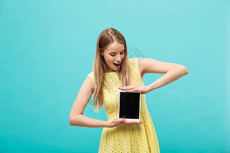 以平板上的wifi为工具接收紧急信息或电子邮件时 面部表达不清或令人困惑的黄色裙子上英俊漂亮的年轻女子激动不已成人女性电脑商业学图片