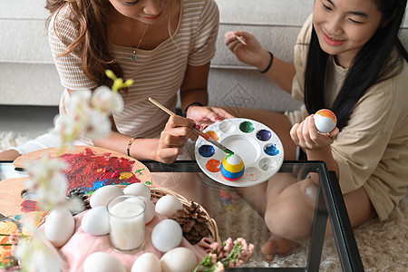 小可爱女孩和妈妈 一起为复活节的庆典做鸡蛋配色准备图片