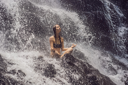 健康水疗 度假和瑜伽冥想概念 热带瀑布岩石上莲花坐姿的年轻女子男人快乐石头温泉生活平衡女性头发女孩成人图片