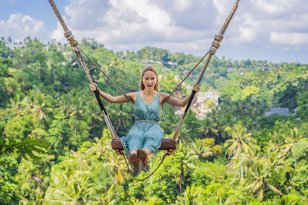 年轻女子在印度尼西亚巴厘岛的丛林雨林中荡秋千 在热带摇摆 秋千巴厘岛的潮流天空女士乐趣高度风景绳索旅行肾上腺素旅游环境图片