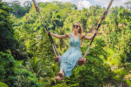 年轻女子在印度尼西亚巴厘岛的丛林雨林中荡秋千 在热带摇摆 秋千巴厘岛的潮流旅游荒野绳索天空游客冒险女性乐趣顶峰森林图片