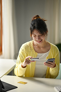 年轻女性使用手机在线购物 智能支付交易汇款技术购买产品图片