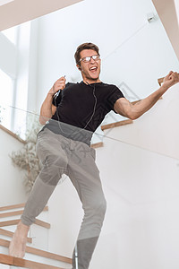 欢乐快乐的人跳舞 他最喜欢的音乐眼镜播客技术楼梯公寓唱歌男性情绪耳机成人图片