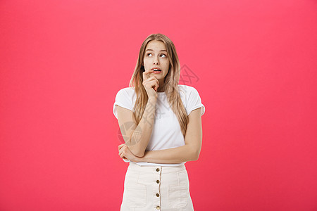 一位年轻女性害怕 恐惧和焦虑地咬指甲的近距离肖像 她望着镜头 睁大眼睛在粉红背景上被孤立 人类情感危险挫折女士活力昏迷大学青少年图片