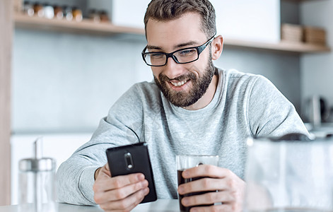 男人在早餐时看电子邮件的书手机电话细胞短信桌子阅读杯子胡须互联网房子图片