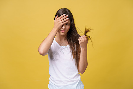 女人握着她的长发 看着受伤的分头 头发护理问题 掌声压力女性发型女士工作室黑发损害情感成人女孩图片