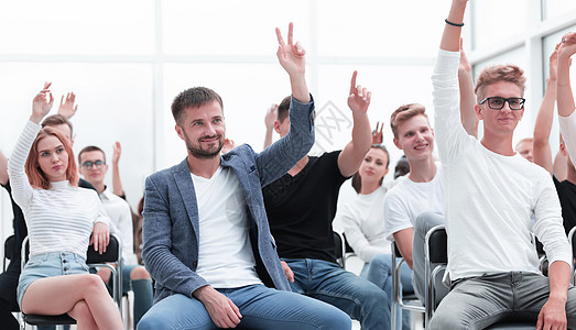 一群年轻人举起手来问一个问题 笑声会议教学首脑伙伴职场作坊男性合作商业同事图片