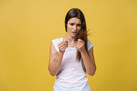 女人握着她的长发 看着受伤的分头 头发护理问题 掌声损害情感成人黑发女士女性压力工作室发型女孩图片