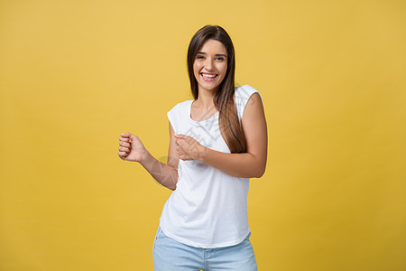 一位快乐的年轻女子在黄色背景下跳舞的肖像学生舞蹈头发女士女孩音乐乐趣青年微笑工作室图片