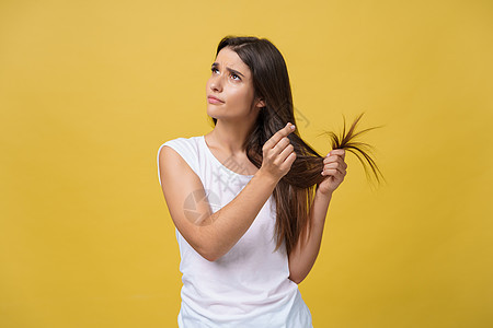 女人握着她的长发 看着受伤的分头 头发护理问题 掌声女性女士发型损害女孩压力成人工作室黑发情感图片