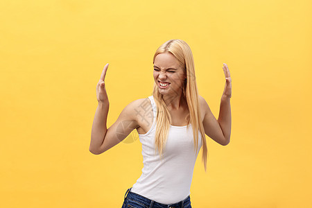 一个快乐快乐的女学生的肖像 与黄色背景隔绝的舞伴音乐发型情感工作室闲暇黑发微笑乐趣女士头发图片