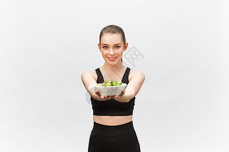 健康健康的妇女吃沙拉和站立 与白种背景隔绝黄瓜饮食女性蔬菜控制营养成人重量产品活力图片