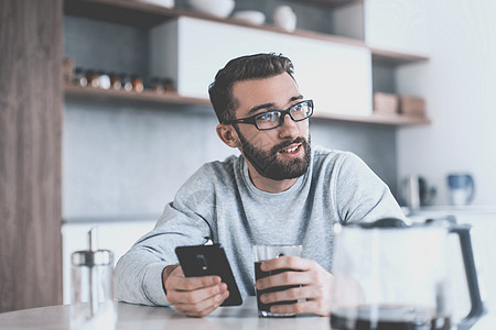 男人在早餐时看电子邮件的书阅读桌子房间杯子电话男性网络享受饮料咖啡图片