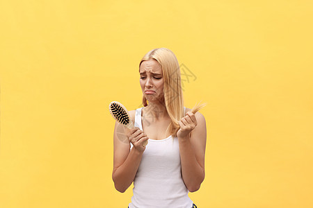 悲伤的女孩看着她手拿着梳子的破发型沙龙损失治疗洗发水压力女性头皮面具保健香脂图片