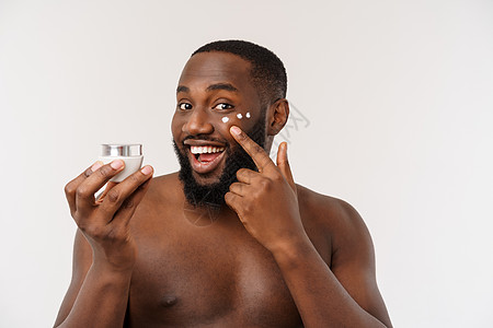 非洲英俊男子在脸上涂奶油 男人的皮肤护理概念身体微笑成人治疗爆炸化妆品潮人工作室肤色温泉图片