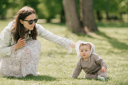 一位年轻母亲正在草地上玩耍7个月的女儿图片
