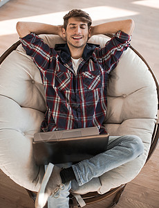 疲累的家伙坐在一个开放的笔记本电脑前自由职业者疲劳休息男人学生椅子说谎家具技术工作背景图片