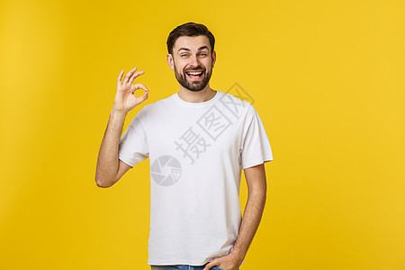 一个快乐的年轻男子的肖像 展示了无忧无虑的姿态 孤立在黄色背景上微笑相机成人衬衫手指学生喜悦男人手势男生图片