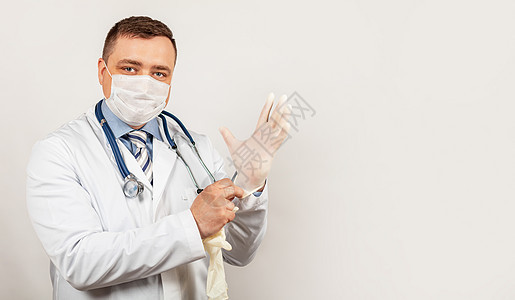 身戴医疗面具和实验室外套 佩戴消菌手套的医生肖像图片