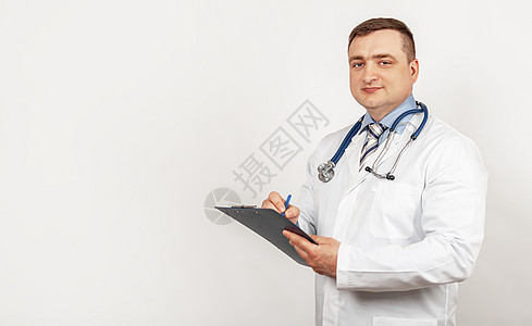 男性医生用笔在平板电脑上写文件 撰写医疗史图片