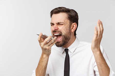 愤怒和严肃的商务人士在电话上用灰色背景交谈技术衬衫商业成人工人工作室男性经理挫折细胞图片