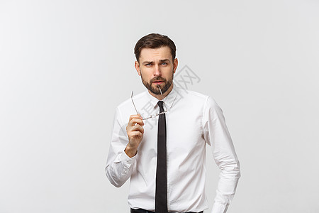 一个英俊的年轻白人千禧年男子 戴眼镜和白色T恤 在灰色工作室背景上被孤立 看着空白副本思维头发学生商业男人商务胡须成人衬衫自由职图片
