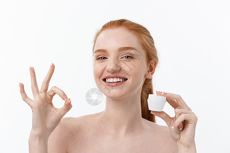 美丽的女人的肖像 在微笑的同时 拿一些面部霜 孤立在白色背景和复制空间女性润肤护理女孩皮肤温泉成人工作室女士治疗图片
