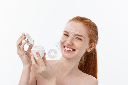 美丽的女人的肖像 在微笑的同时 拿一些面部霜 孤立在白色背景和复制空间治疗润肤快乐奶油女士工作室女孩女性护理黑发图片