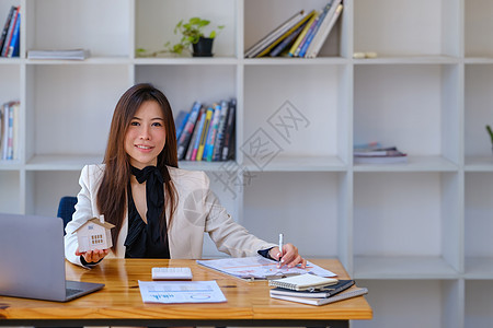 亚洲女会计师 女商务人士 房地产经纪人拿着笔 指着家庭贷款和利息文件来计算家庭投资预算中的风险行政人员协议公寓钥匙零售计算器战略图片