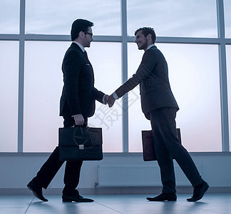 两个商务人士伸出双手握手办公室管理人员会议男性同事工作经理合作公文包手势图片