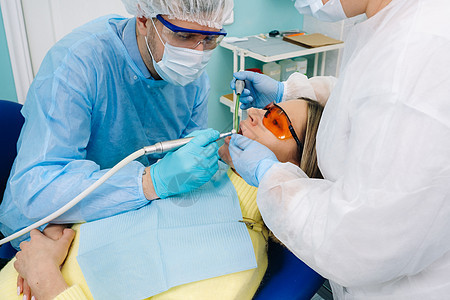 一位带牙科工具的男牙医与助手一起为病人钻牙 医学 牙科和医疗保健的概念治疗考试医生专家椅子访问牙齿口腔微笑手术图片